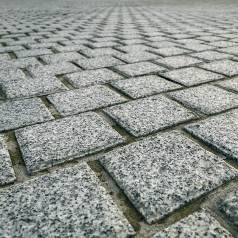 Interlocking paver walkway with linear planting for warehouse pedestrian routes.