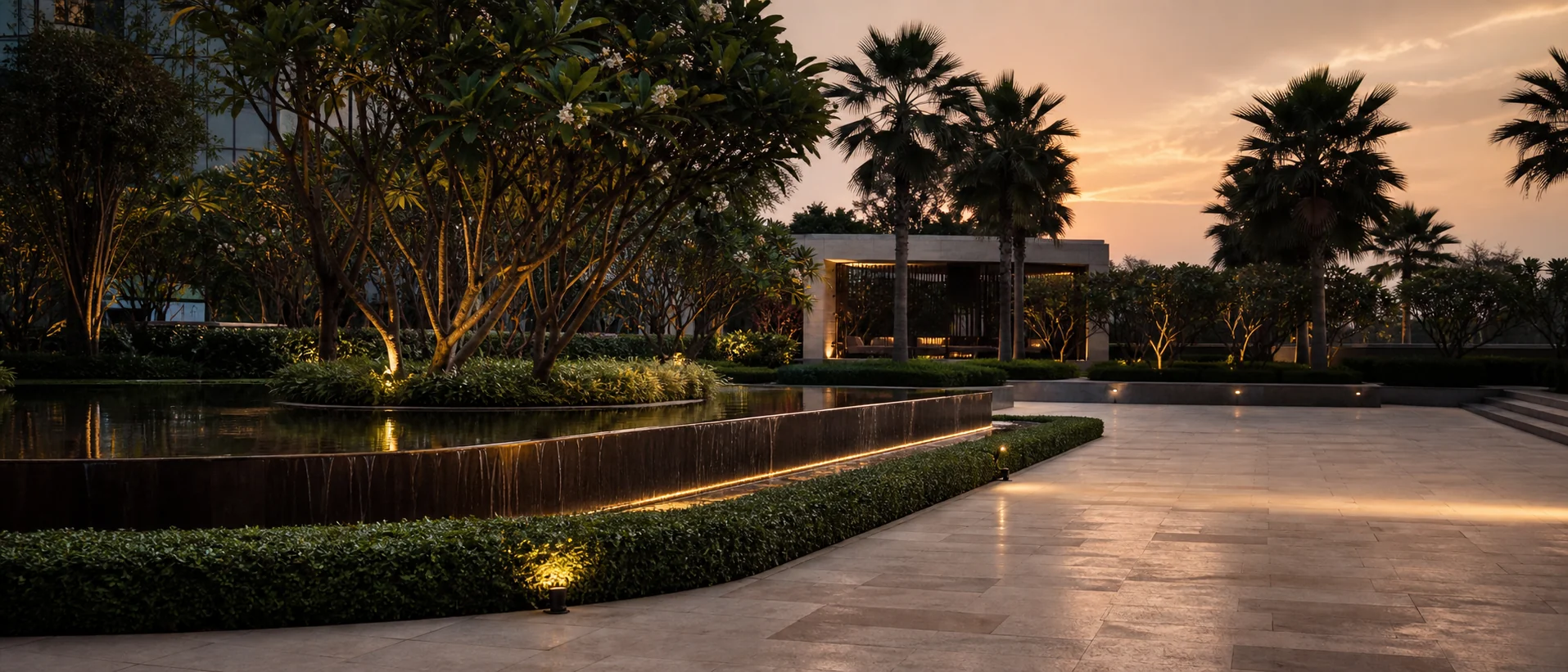 Luxury commercial landscape hero showing structured planting, walkway rhythm, and high-end outdoor ambience.