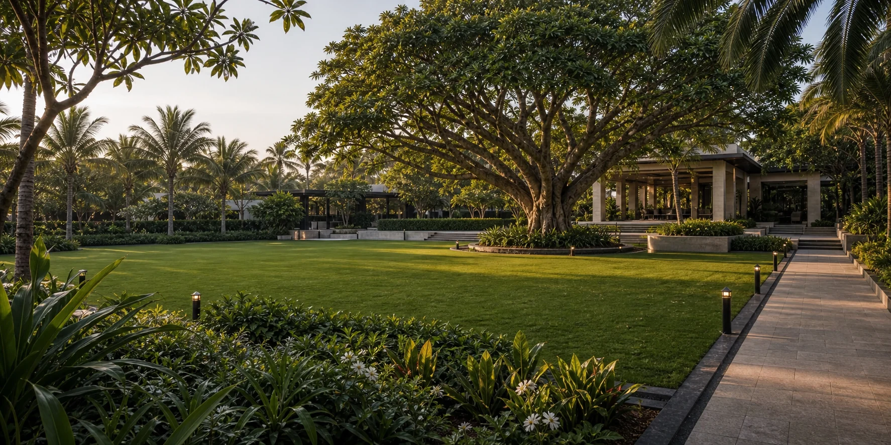 Resort landscape with lawn, mature tree canopy, and relaxed outdoor guest amenity space.
