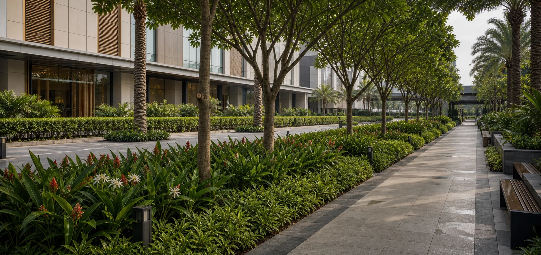 Mall evening landscape with warm path lighting, trees, and planted public realm edges.