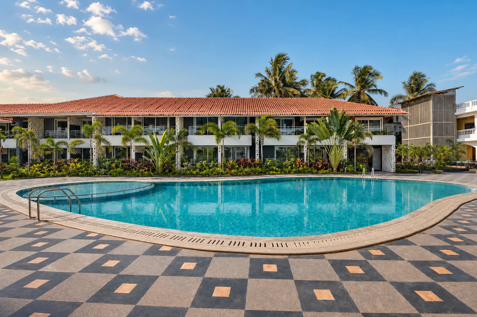 Hyatt Place Goa Candolim wide main-pool panorama with guest-room facade, clear turquoise water and formal tropical landscaping