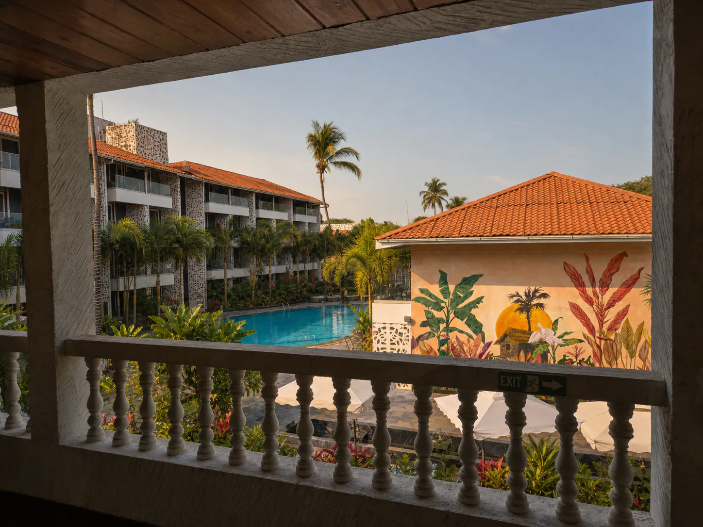 Hyatt Place Goa Candolim elevated view toward the tropical mural, pool and landscaped guest-room courtyard