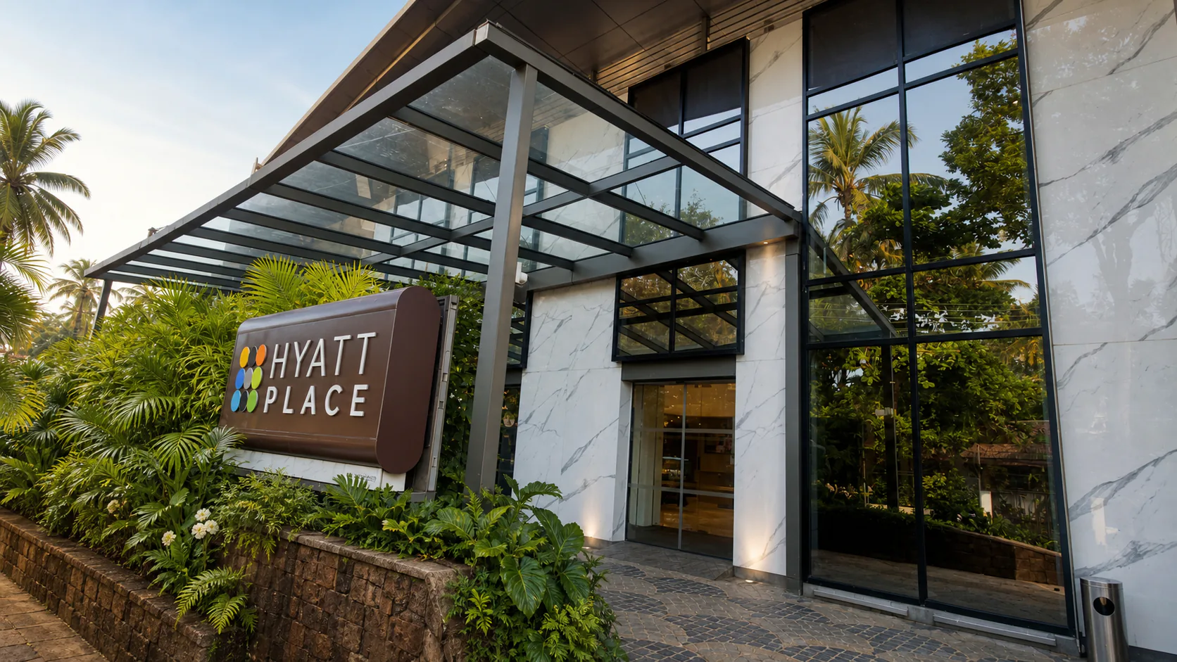 Hyatt Place Goa Candolim hyatt Place entrance sign, glass canopy and marble facade framed by tropical greenery