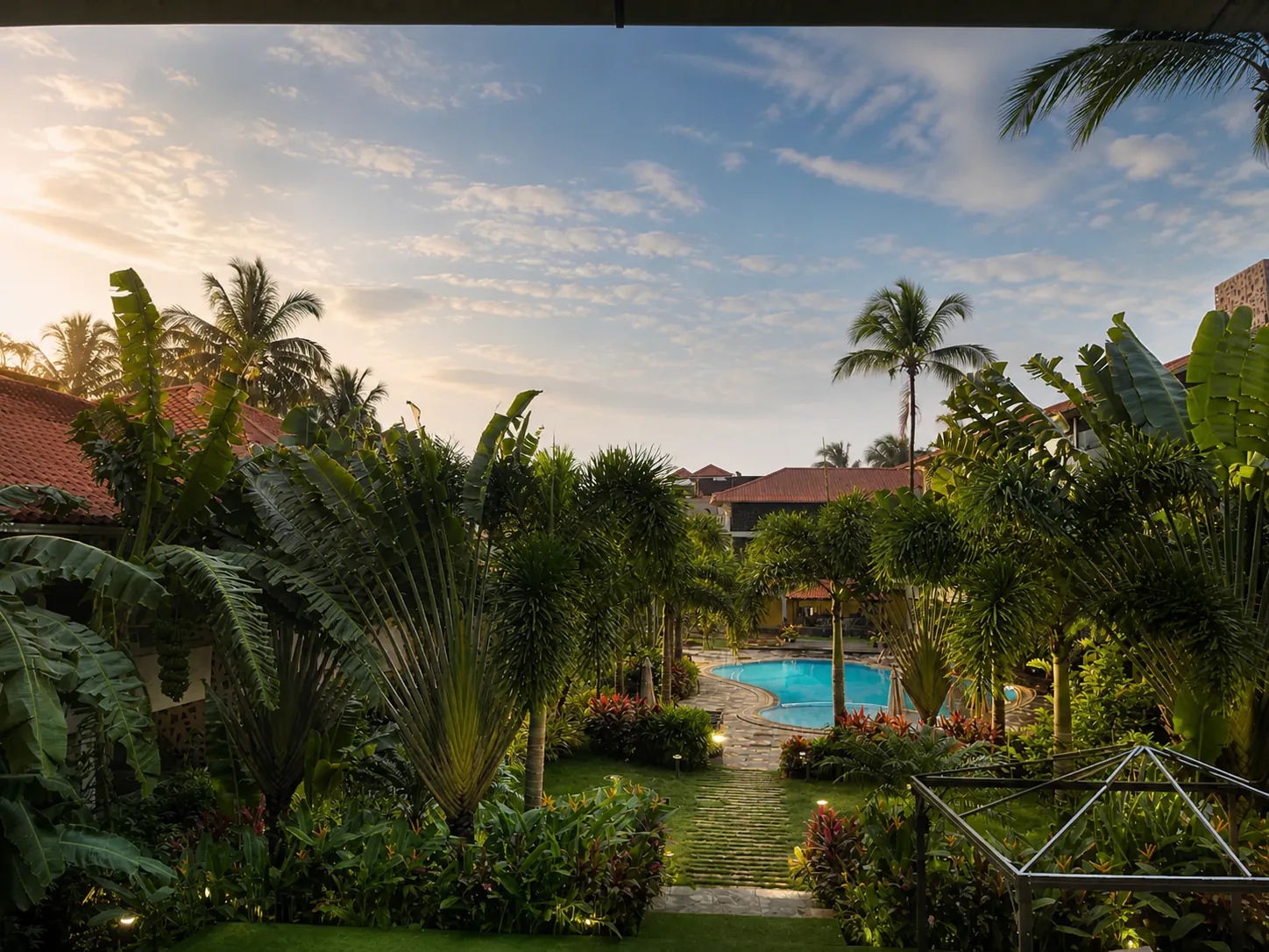 Hyatt Place Goa Candolim elevated golden-morning view through tropical palms toward the pool