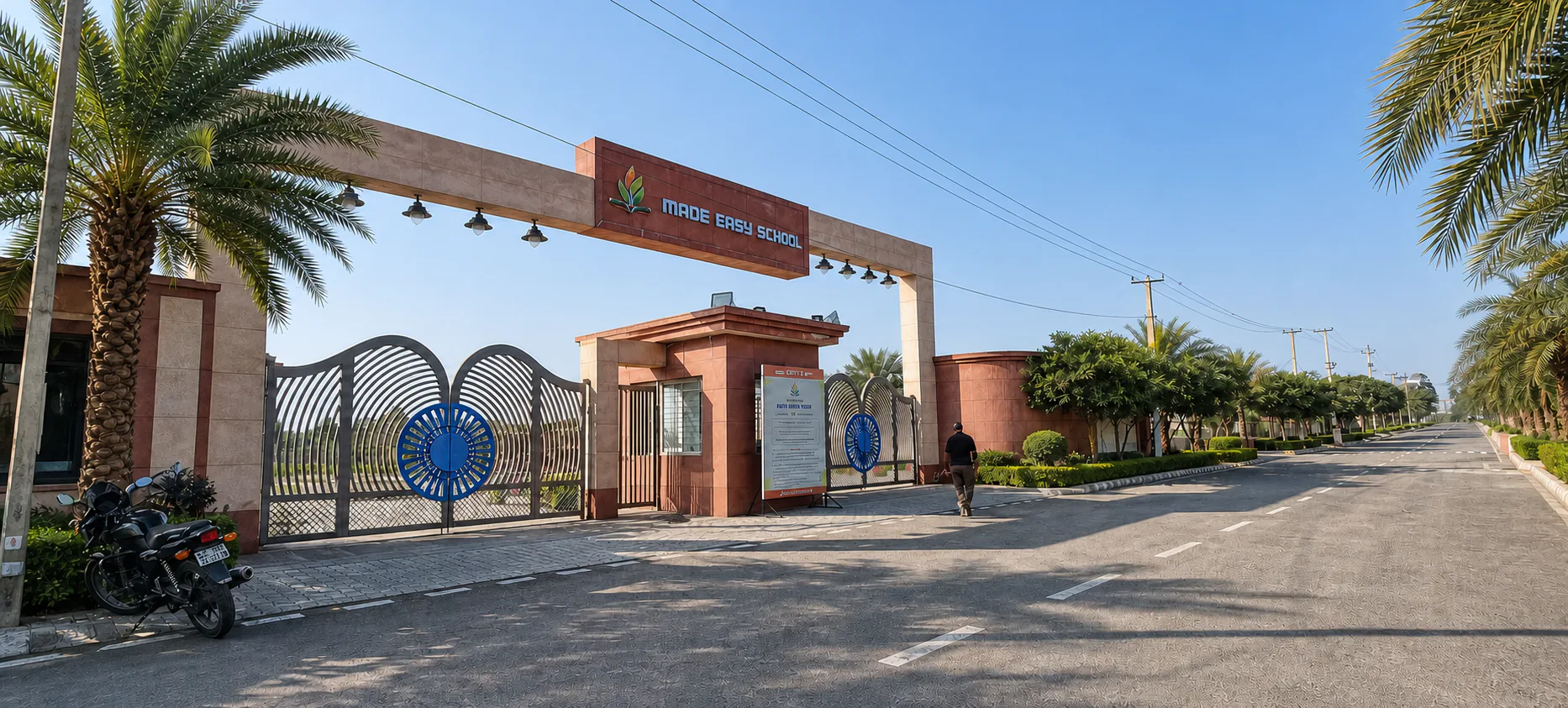 Made Easy School Bhandwari entrance portal with patterned gates, clean approach road, mature palms and evergreen planting