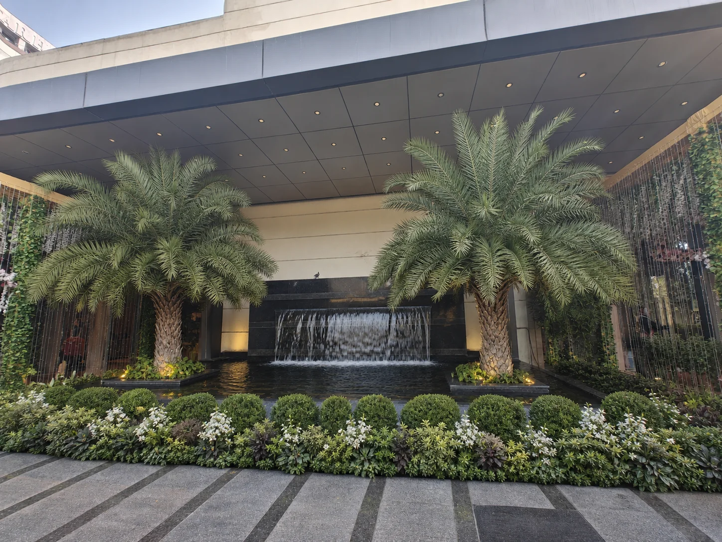 Silver Spoons Ghaziabad entrance with mature date palms, waterfall and structured planting