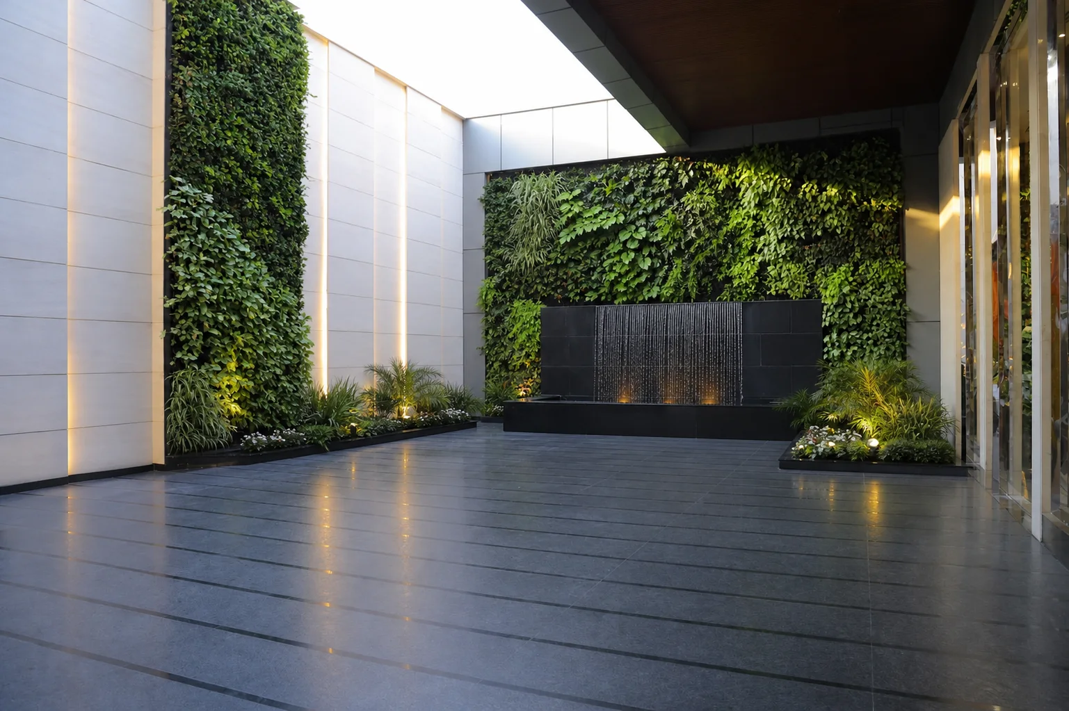Silver Spoons open courtyard with two planted walls, an active black-stone water feature and minimal edge planting.