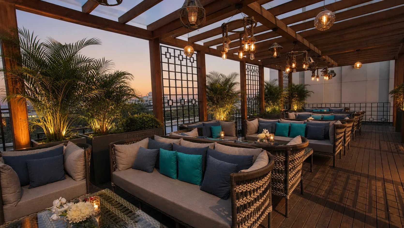Silver Spoons rooftop lounge at sunset with warm timber finishes, compact palms and understated hospitality lighting.