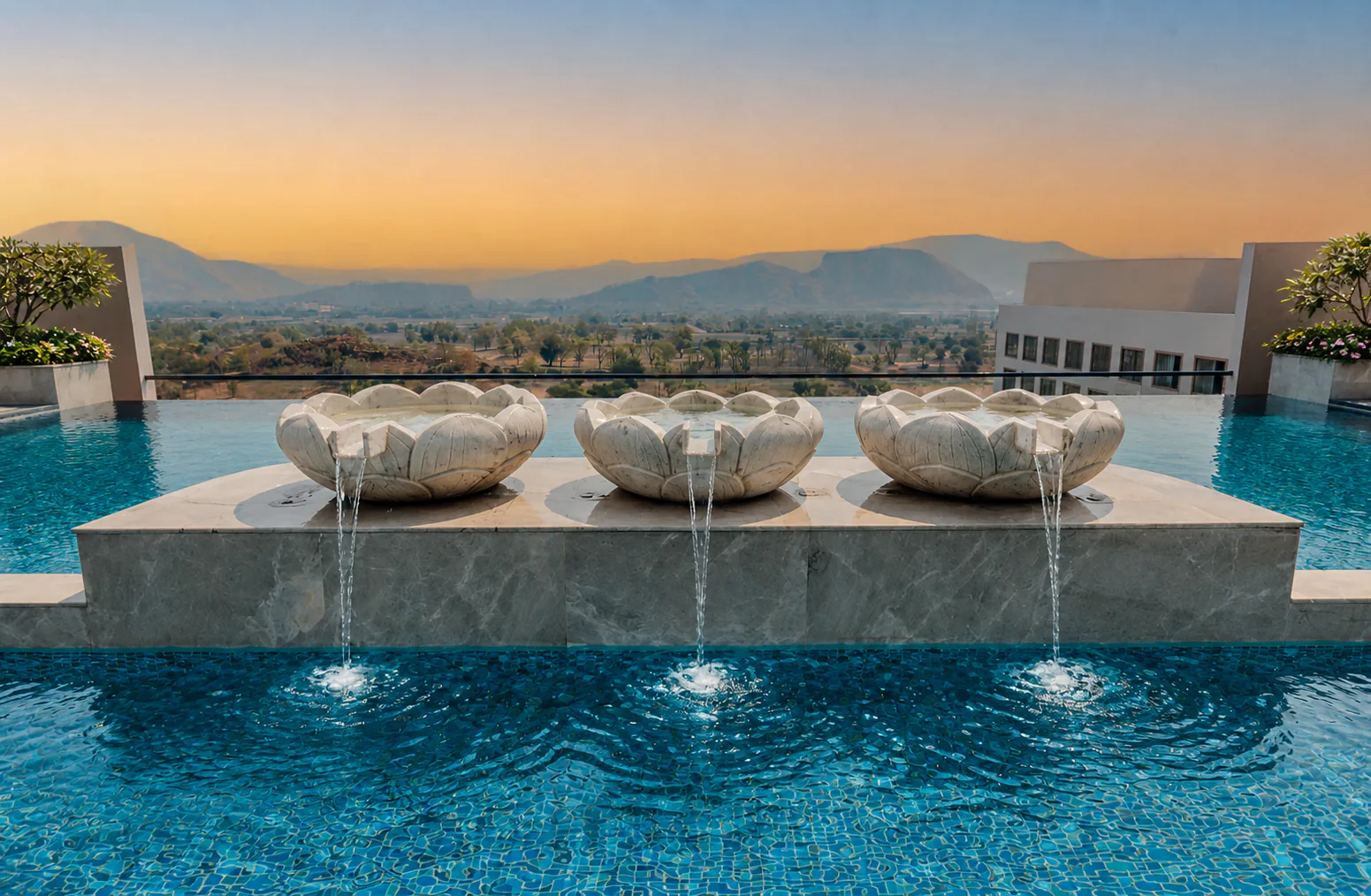 Taj Amer Jaipur rooftop lotus pool with three carved fountains, clear water and the Aravalli hills beyond.