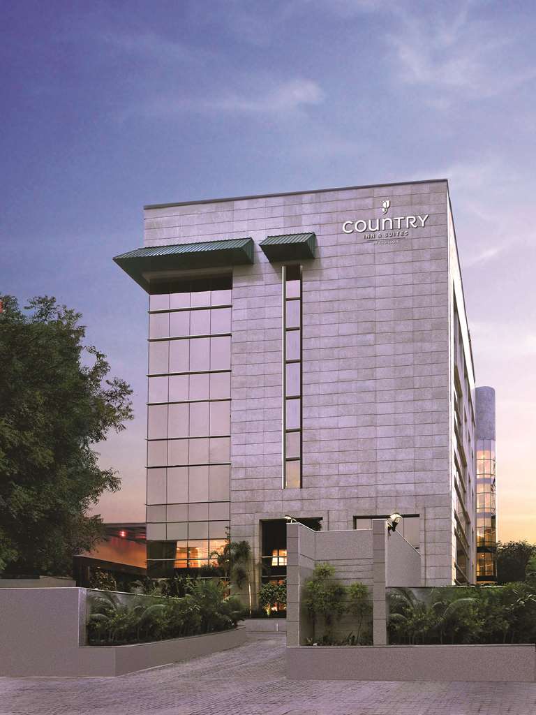 Exterior view of Country Inn & Suites Gurugram Sector 12 with Four Leaf Landscape's greenery.